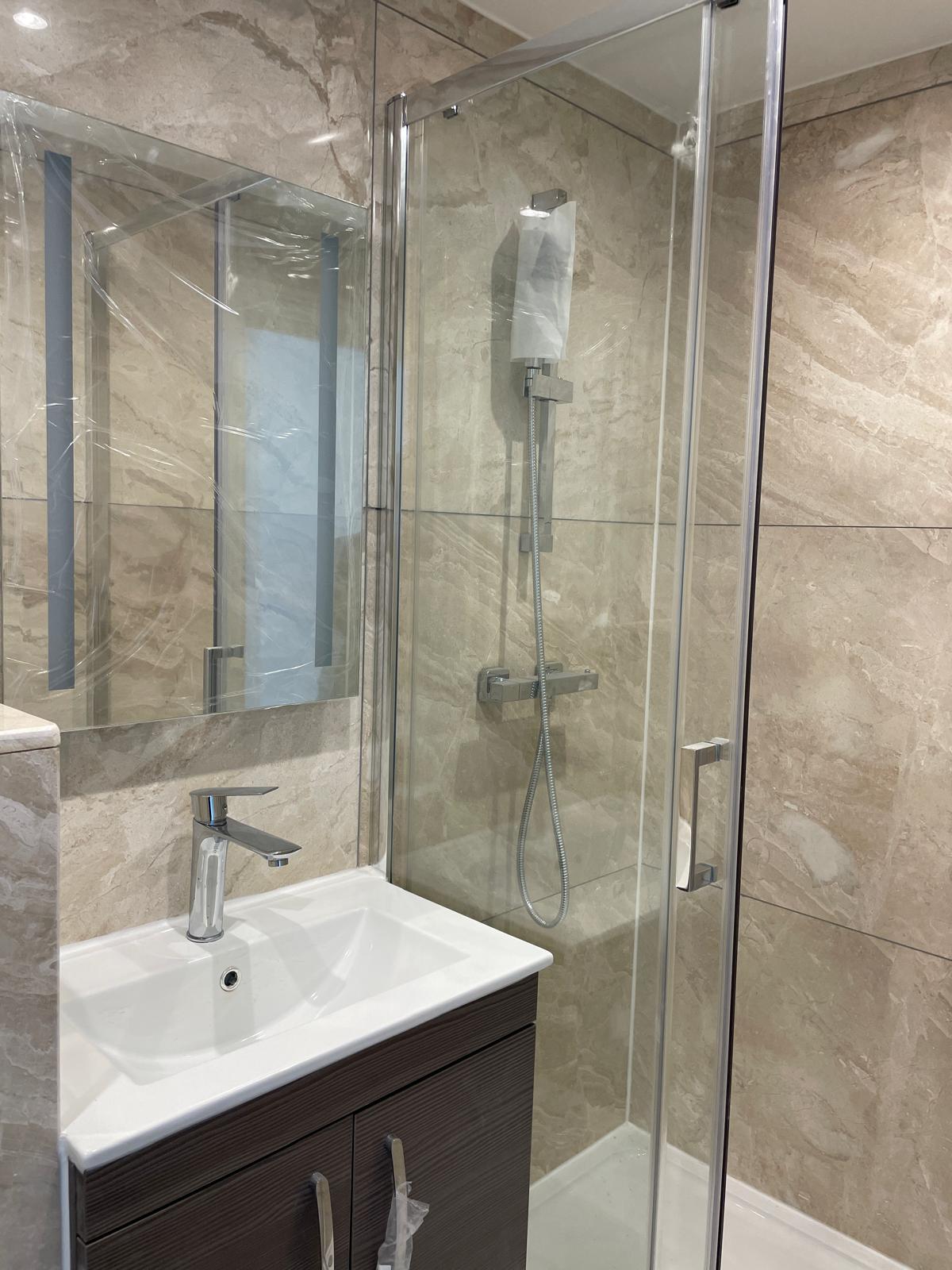 Finished bathroom vanity and shower enclosure.