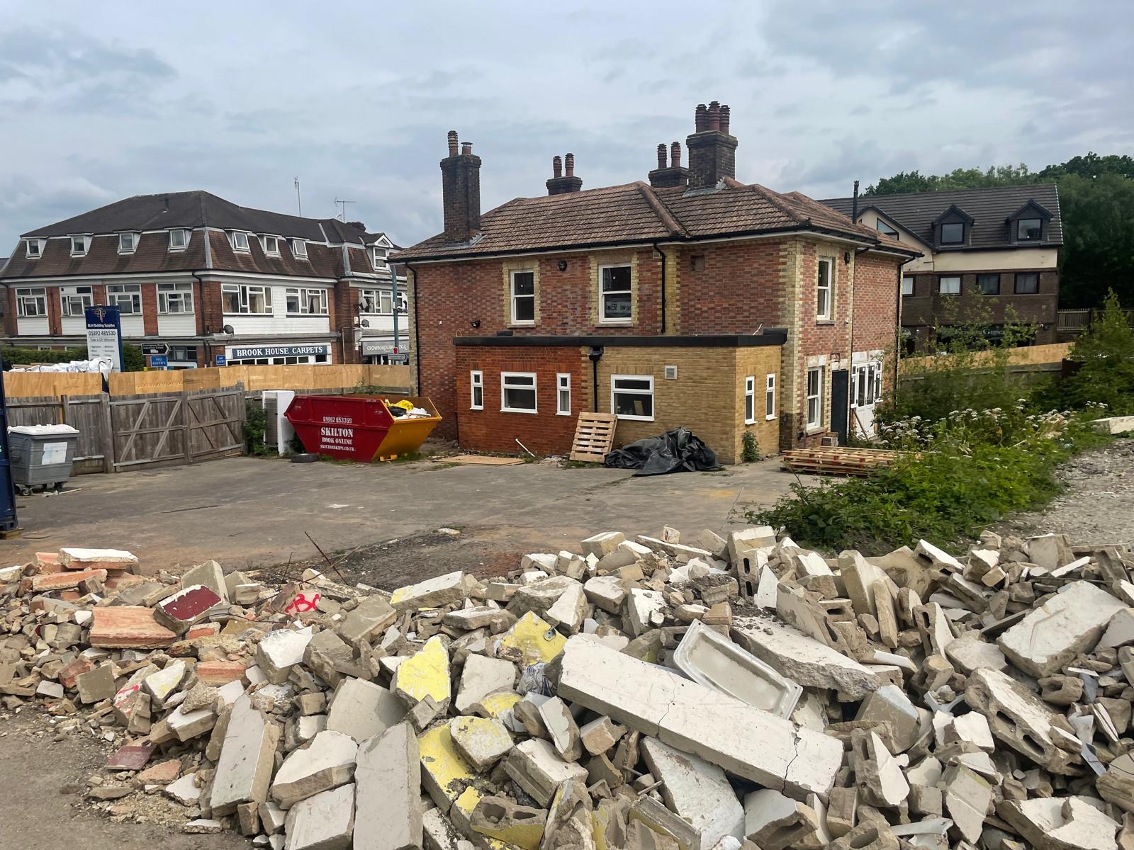 Demolition of the rear element, with rubble stockpiled for removal.