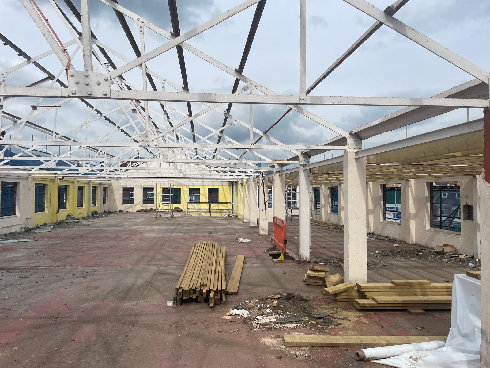 Roof trusses exposed, with treated timber delivered for the works.