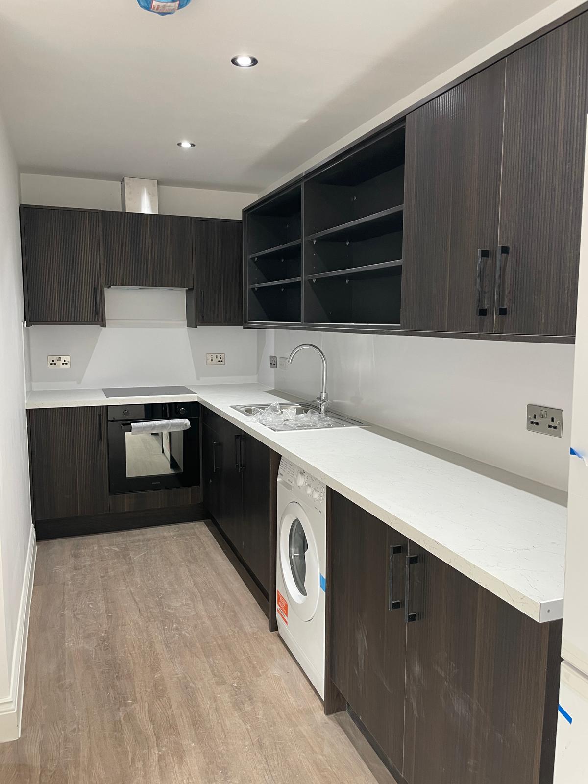 Finished kitchen with worktops and integrated appliances.