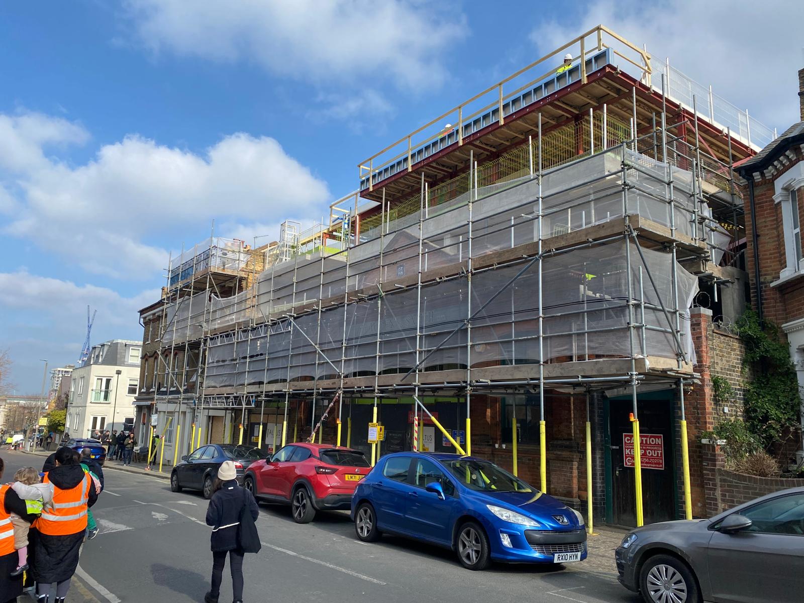 Street elevation scaffolded for the rooftop extension works.