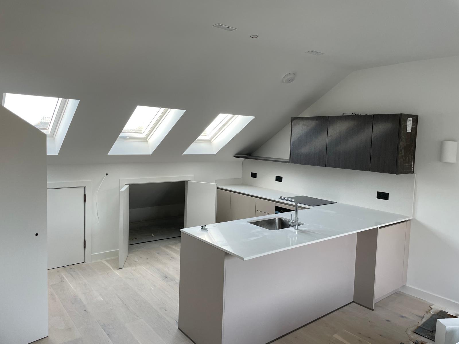 Penthouse kitchen fitted beneath the new rooflights.