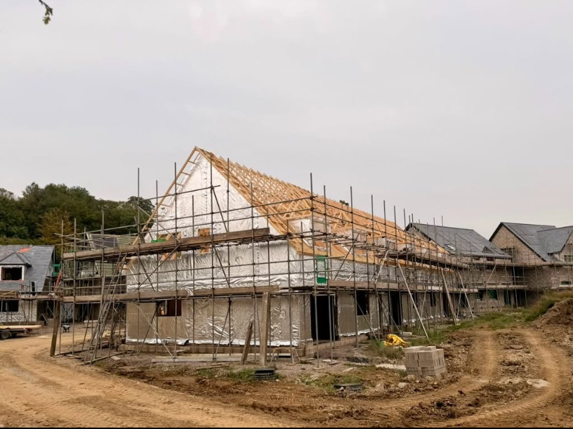 Timber frame homes with sheathing and roof structures under construction
