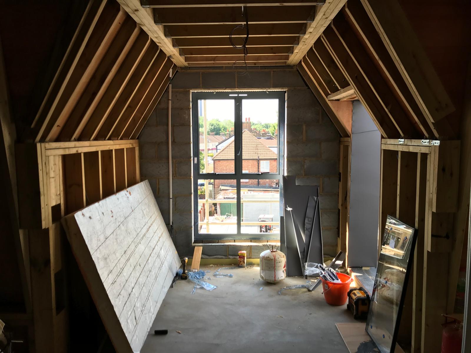 A dormer room framed out with the window opening formed.