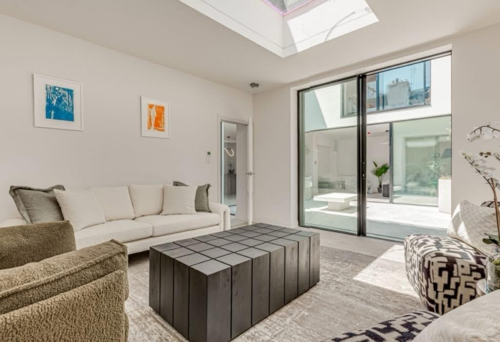 Finished living room with rooflight and courtyard access.