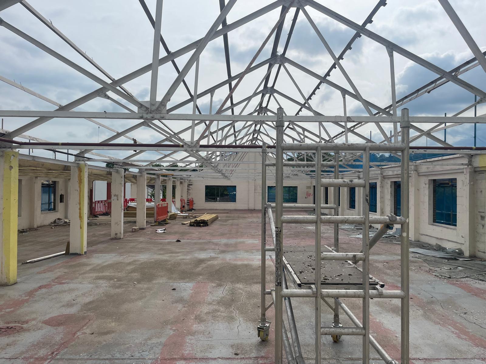 Original steel roof trusses exposed during the strip out.