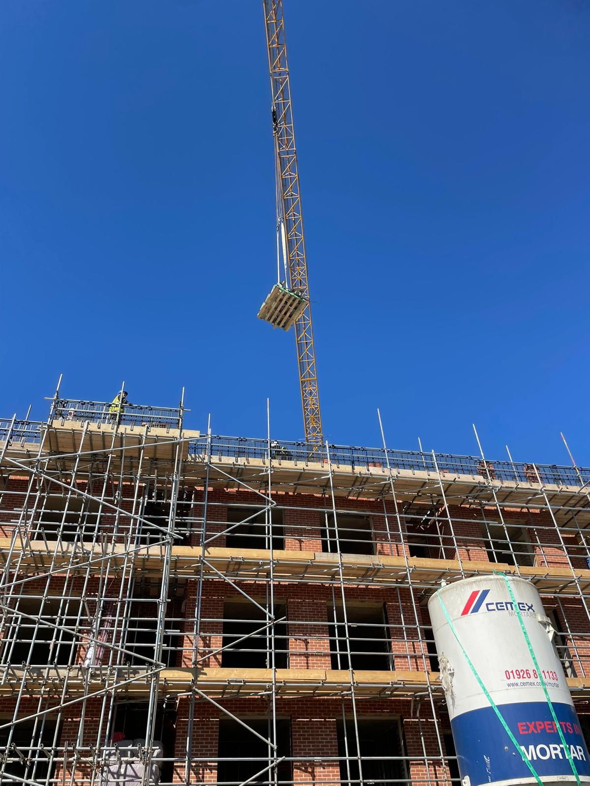 The tower crane lifting materials to the upper floors.