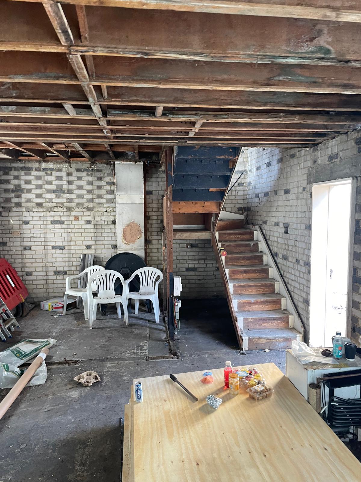 Ground floor strip out, with existing floor and ceiling structure removed.