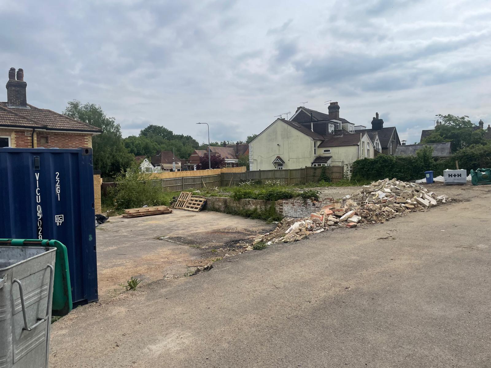 Site cleared, with demolition rubble stockpiled for collection.